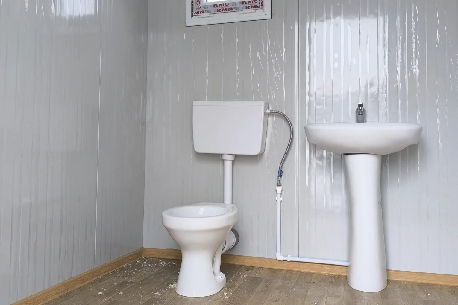 Imagine Container Sanitar – Dotat cu WC, chiuvetă, o ușă și un geam mic. Perfect pentru șantiere sau zone fără utilități.